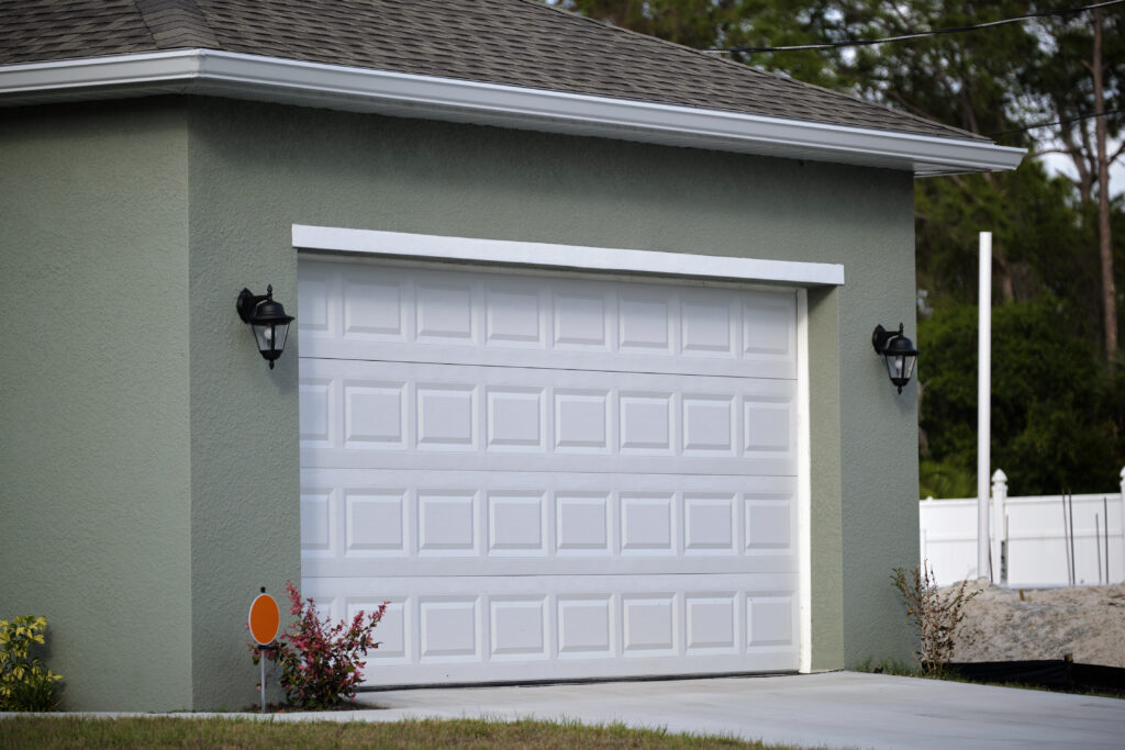 Green house with white garage door