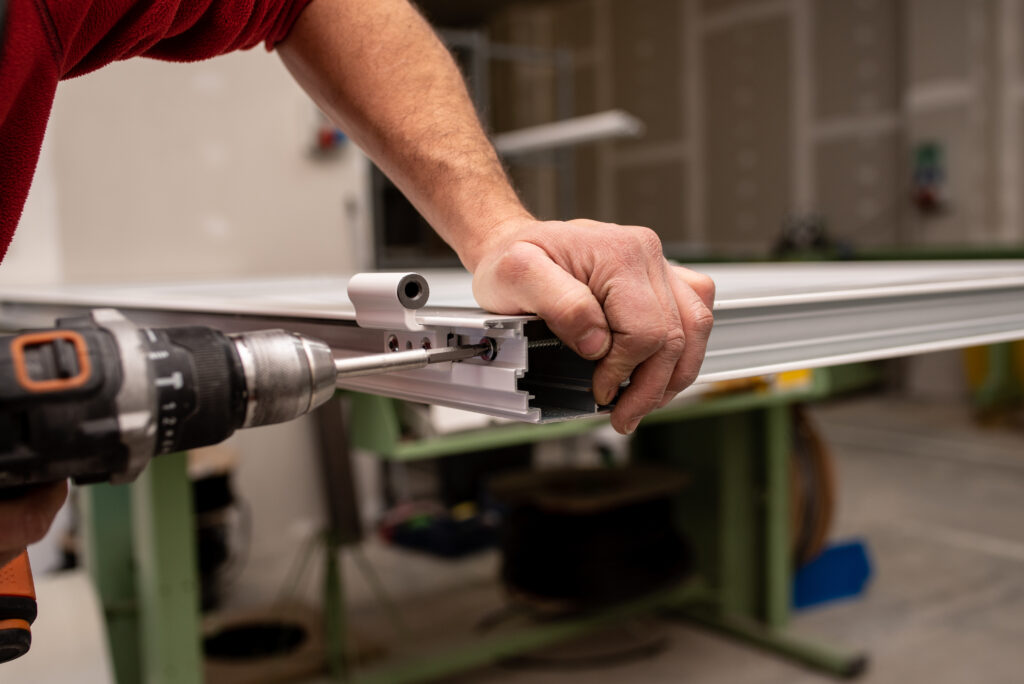 a man uses drill on the side of the garage door